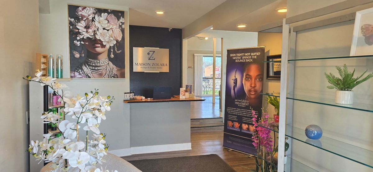 Maison Zolara reception desk with floral artwork and Candela Matrix display in Lansing, Michigan