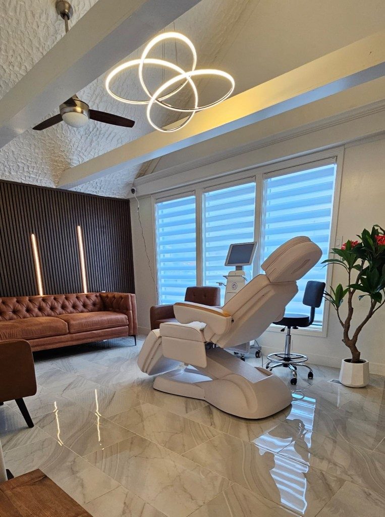 Maison Zolara private treatment suite with ring chandelier, marble floors, and luxury aesthetic chair in Lansing Michigan